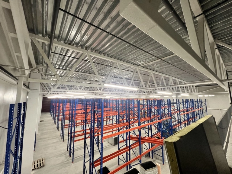 Warehouse with shelving and overhead technical infrastructure